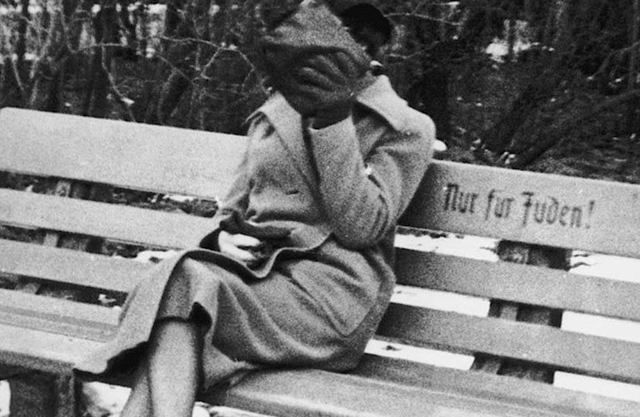 История в фото: девушка закрывает лицо, сидя на скамье с надписью «Только для евреев»